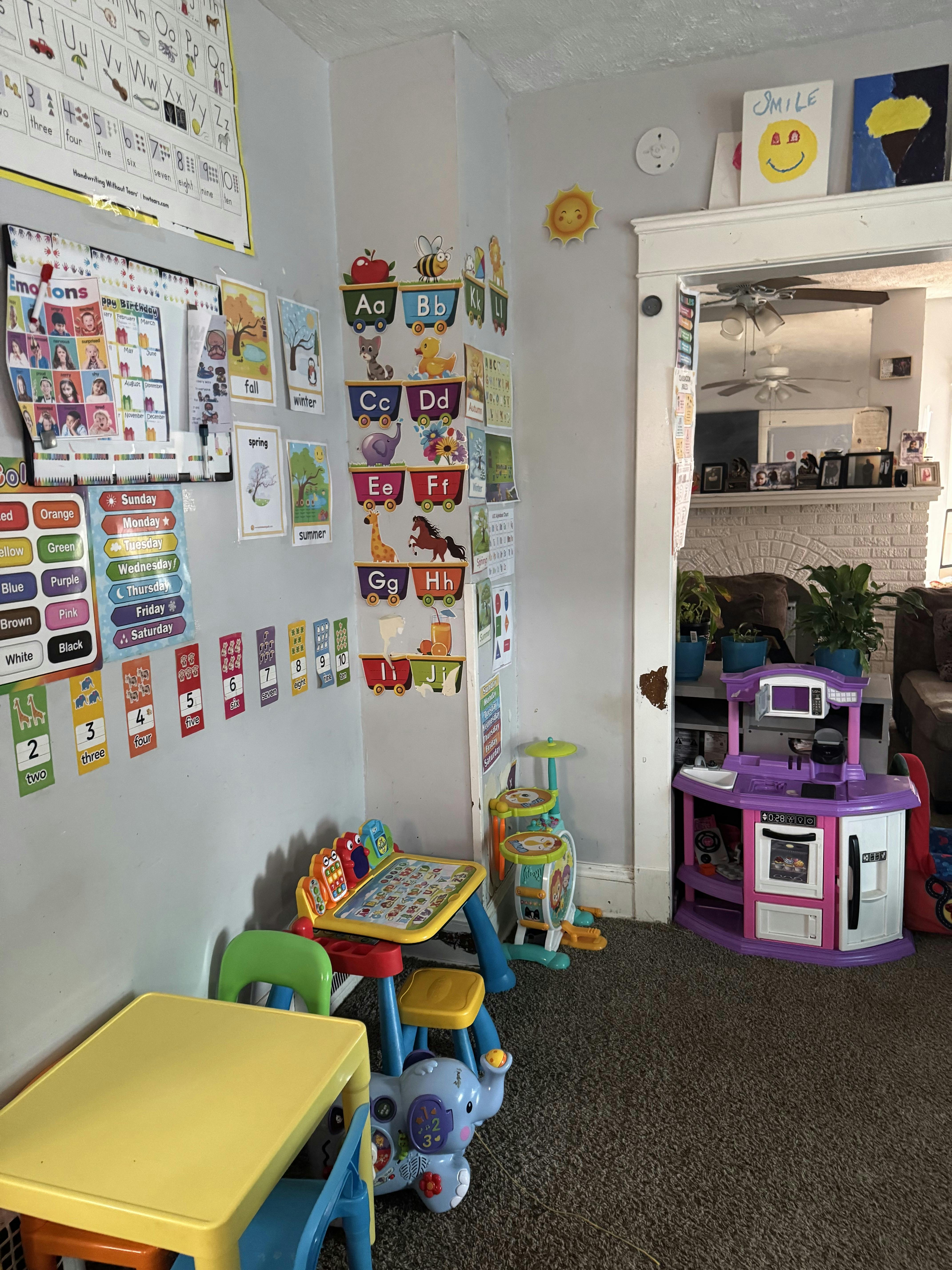 Playroom with alphabet charts, small tables, and a toy kitchen
