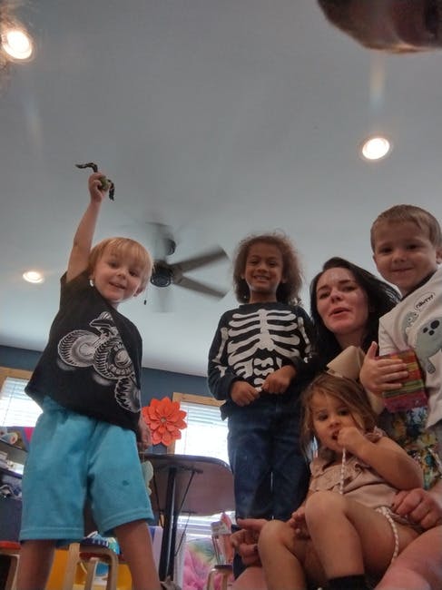 Five people, including three children and an adult, looking up at the camera