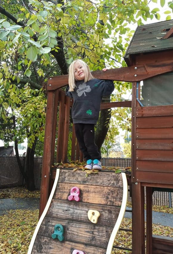 Child standing on a wooden playground structure
