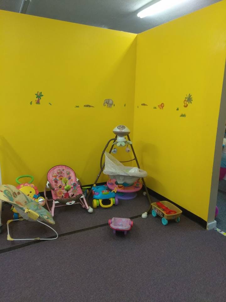 Baby swings and chairs in a room with yellow walls