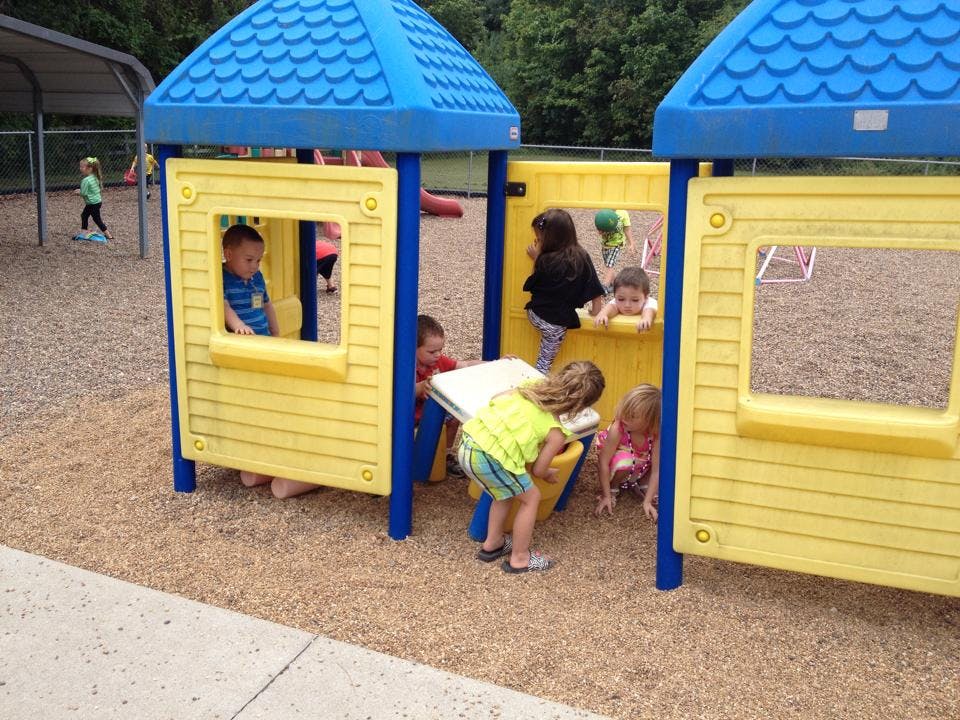 Children playing on a yellow and blue playground structure