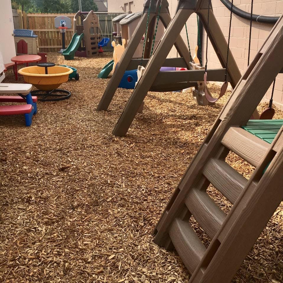 Playground with wood chips, swings, and slides