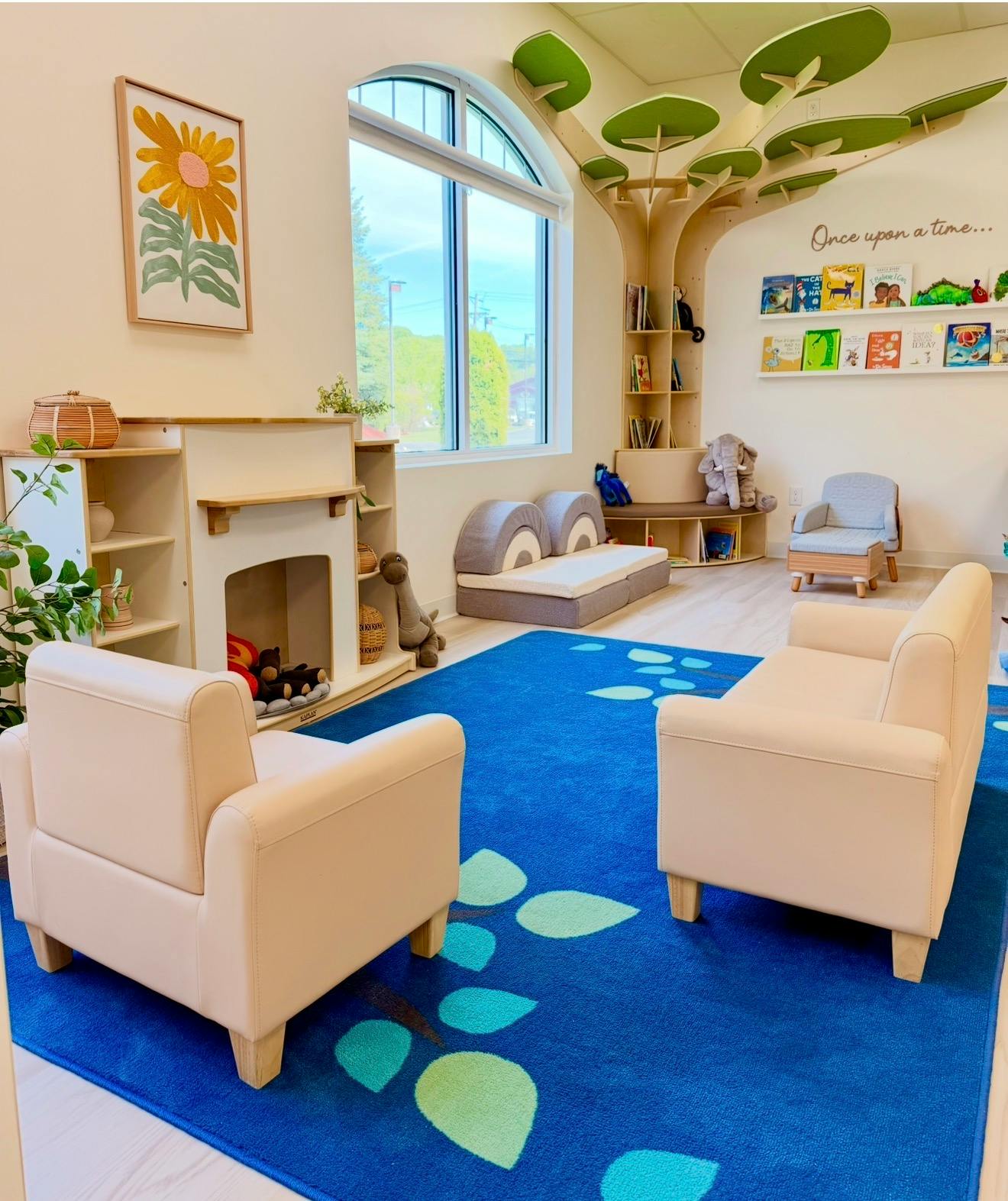 Child-sized reading area with small chairs and bookshelf