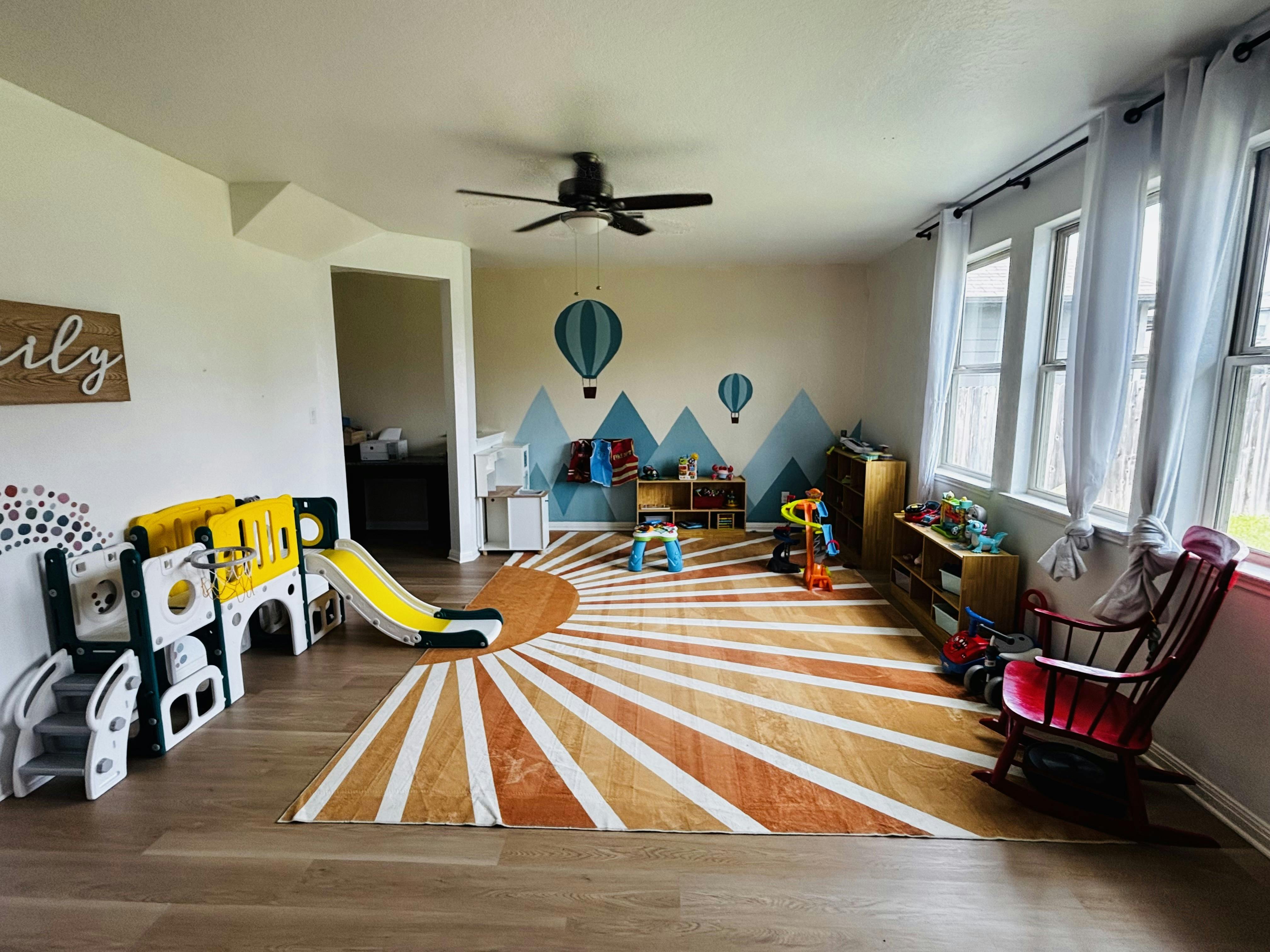 Playroom with a sunburst rug and children play equipment