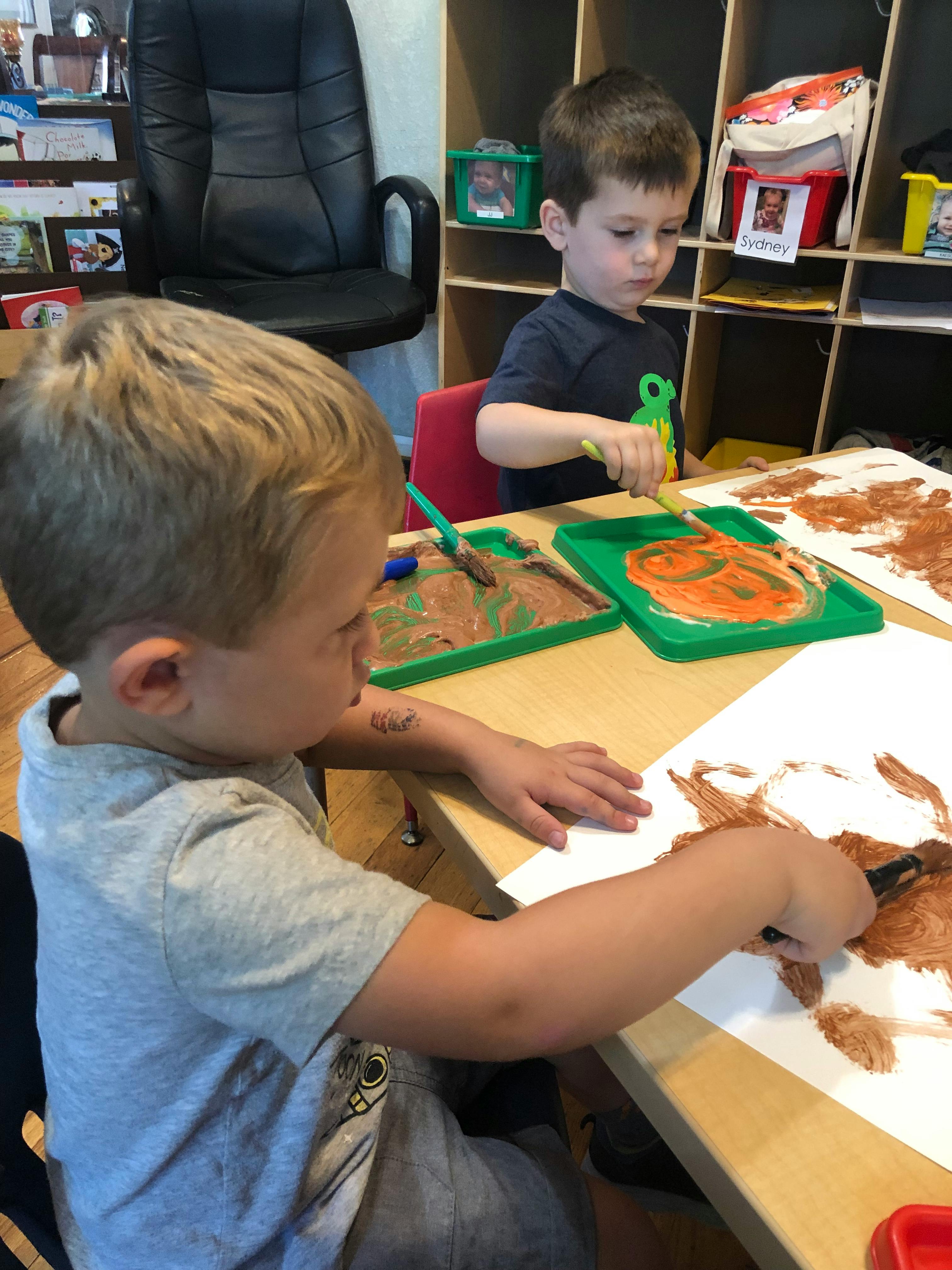 Two children painting at a table