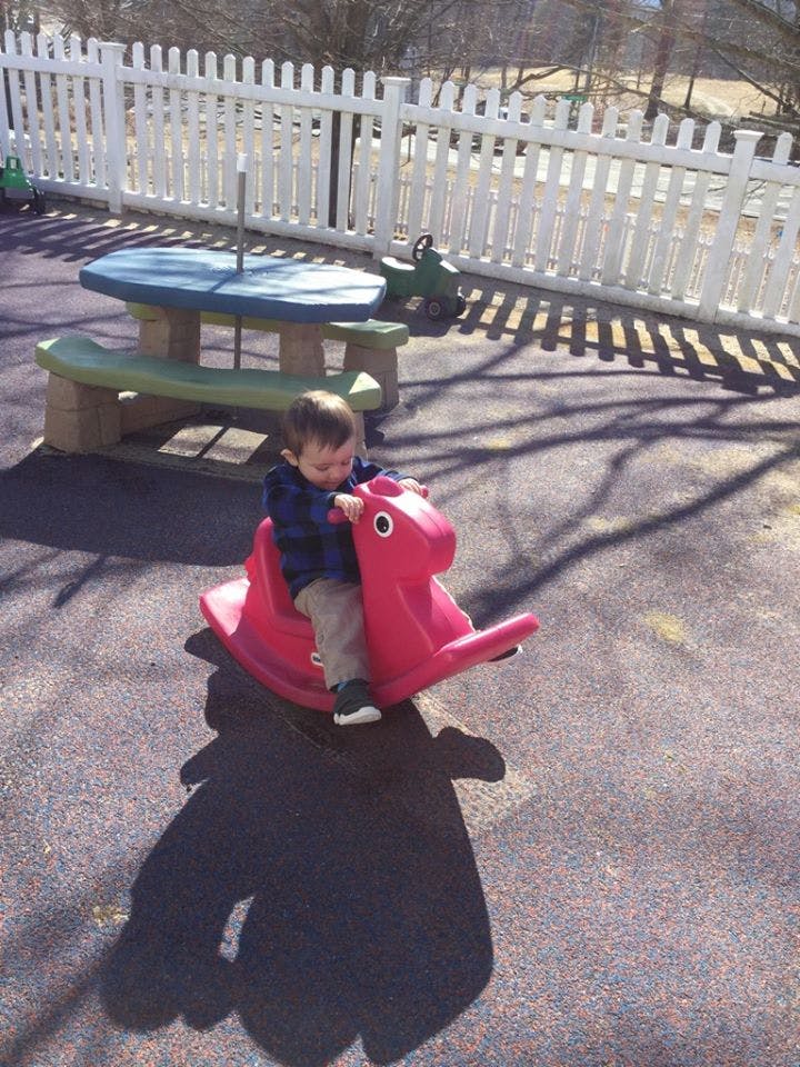 Child on a red spring rider in a playground