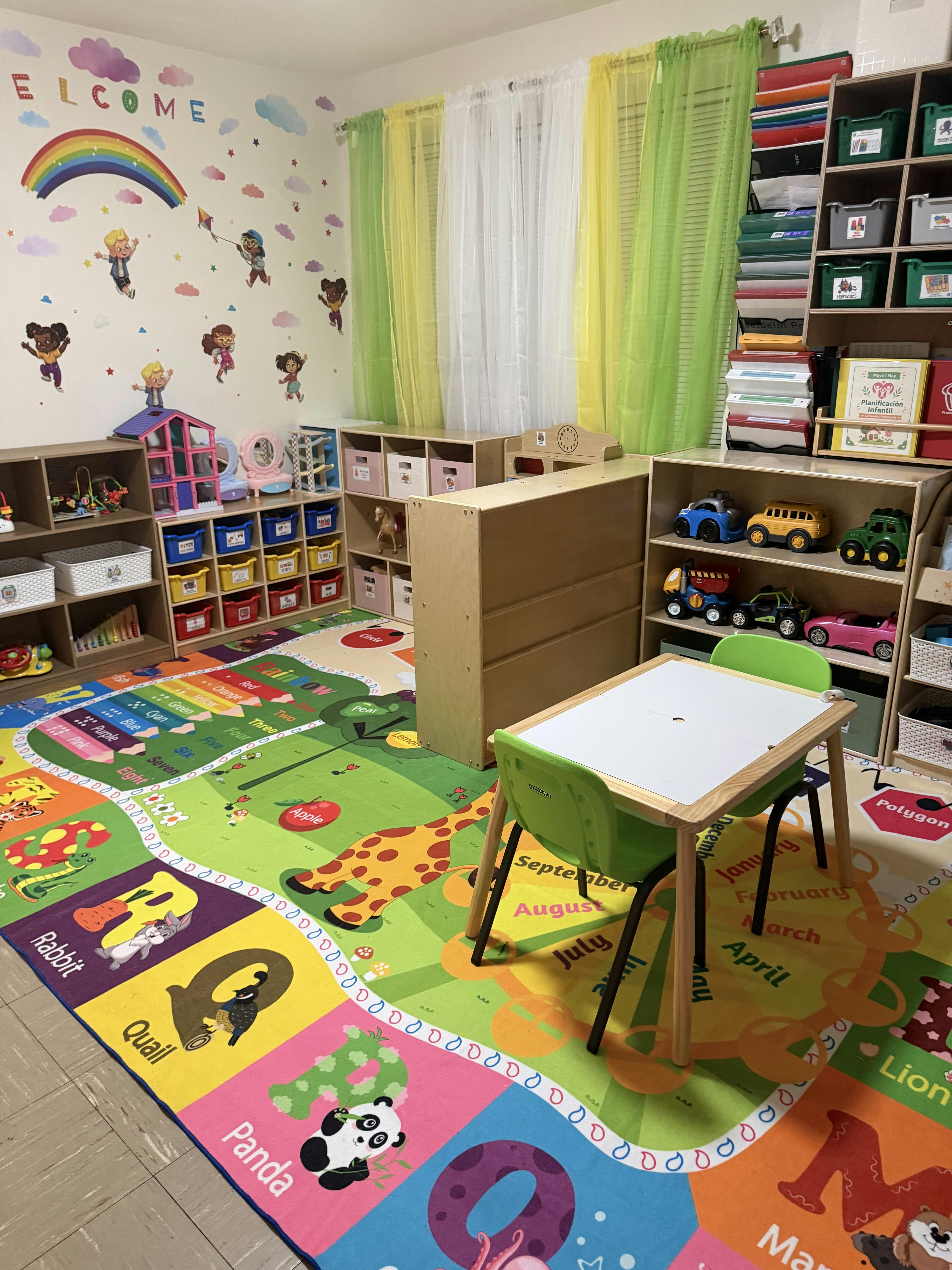 Colorful classroom with educational rugs, toy shelves, and a small table