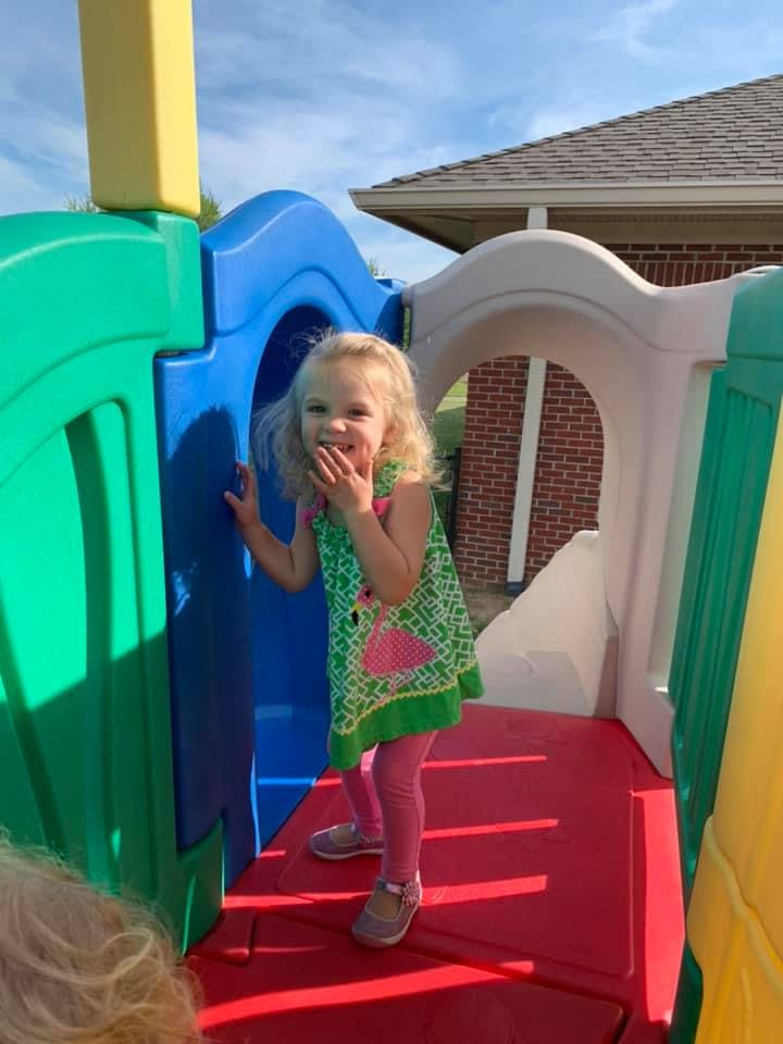 Child standing on a red playground structure