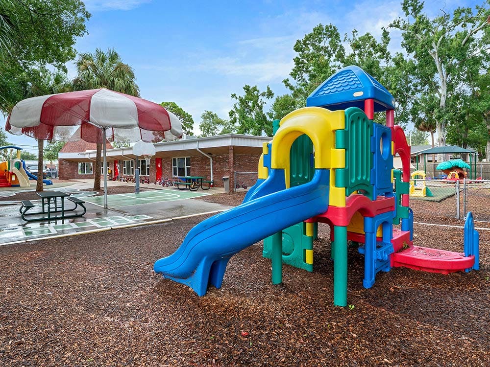 Colorful playground equipment with slides and climbing features on mulch