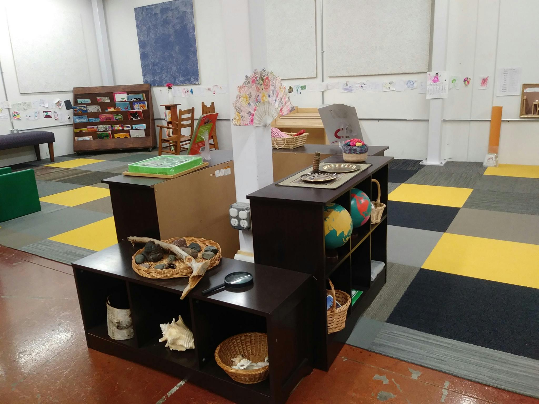 Classroom with shelves of learning materials and a checkered floor