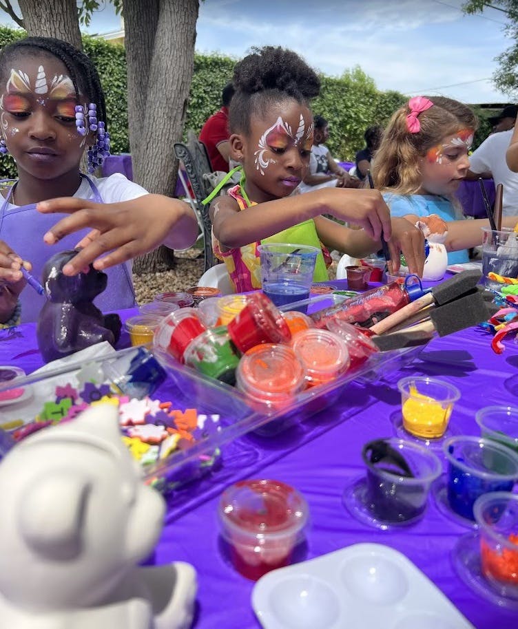 Children painting crafts at a table