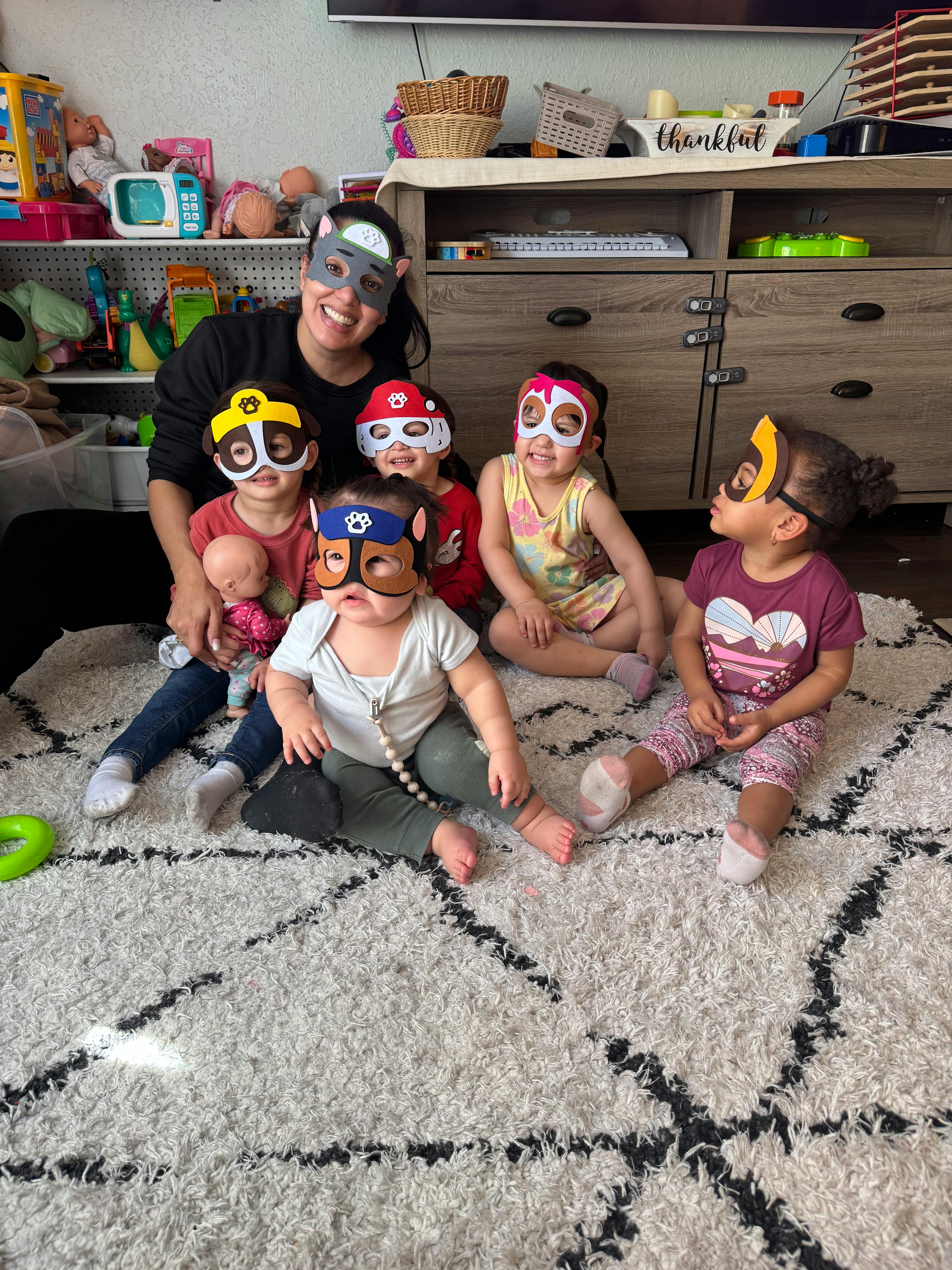 Person and multiple children wearing animal masks