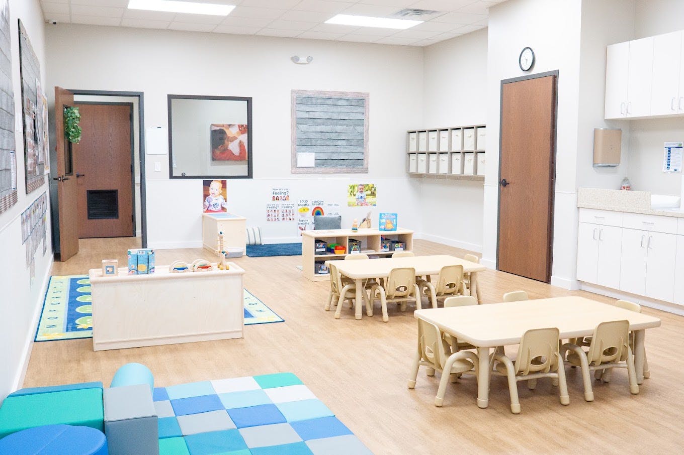 Empty preschool classroom with small tables and chairs