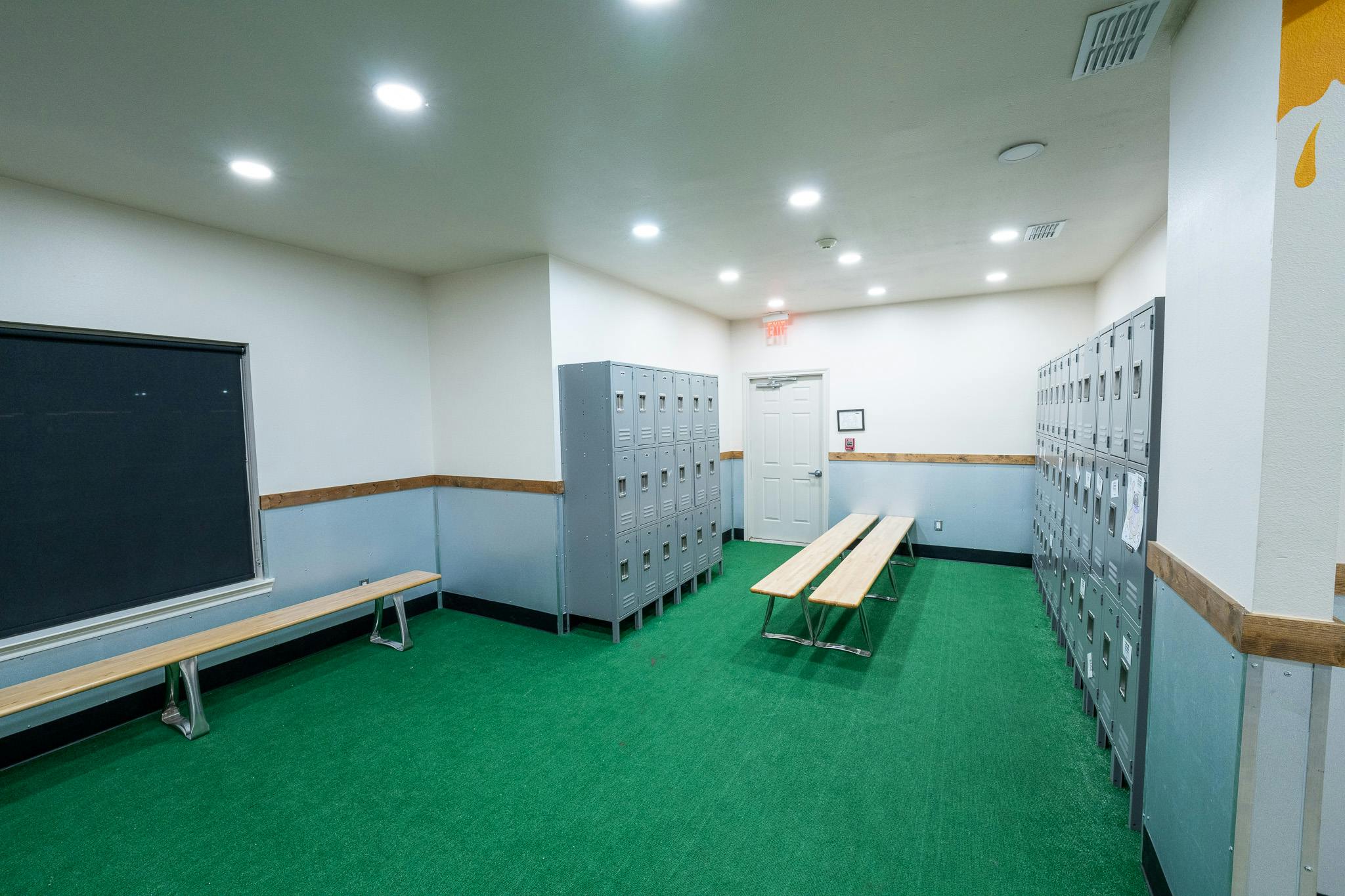 Locker room interior with rows of metal lockers and wooden benches