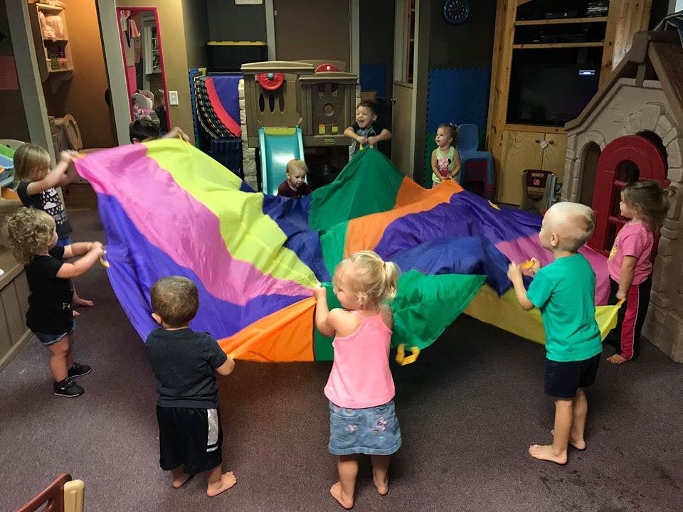 Children playing with a colorful parachute