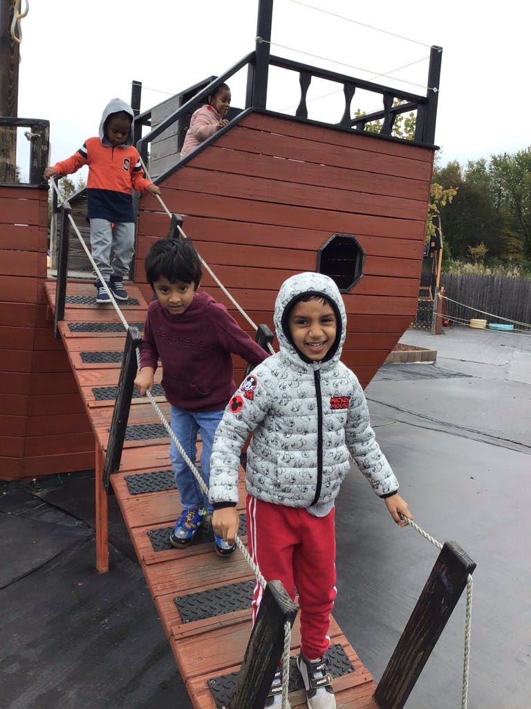 Children playing on a wooden pirate ship structure