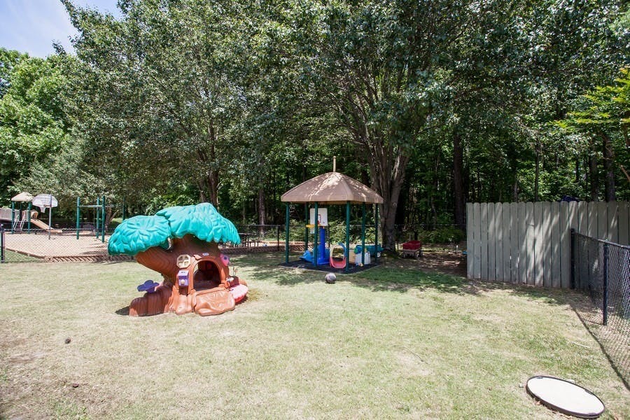 Playground with a tree-shaped play structure and a small gazebo