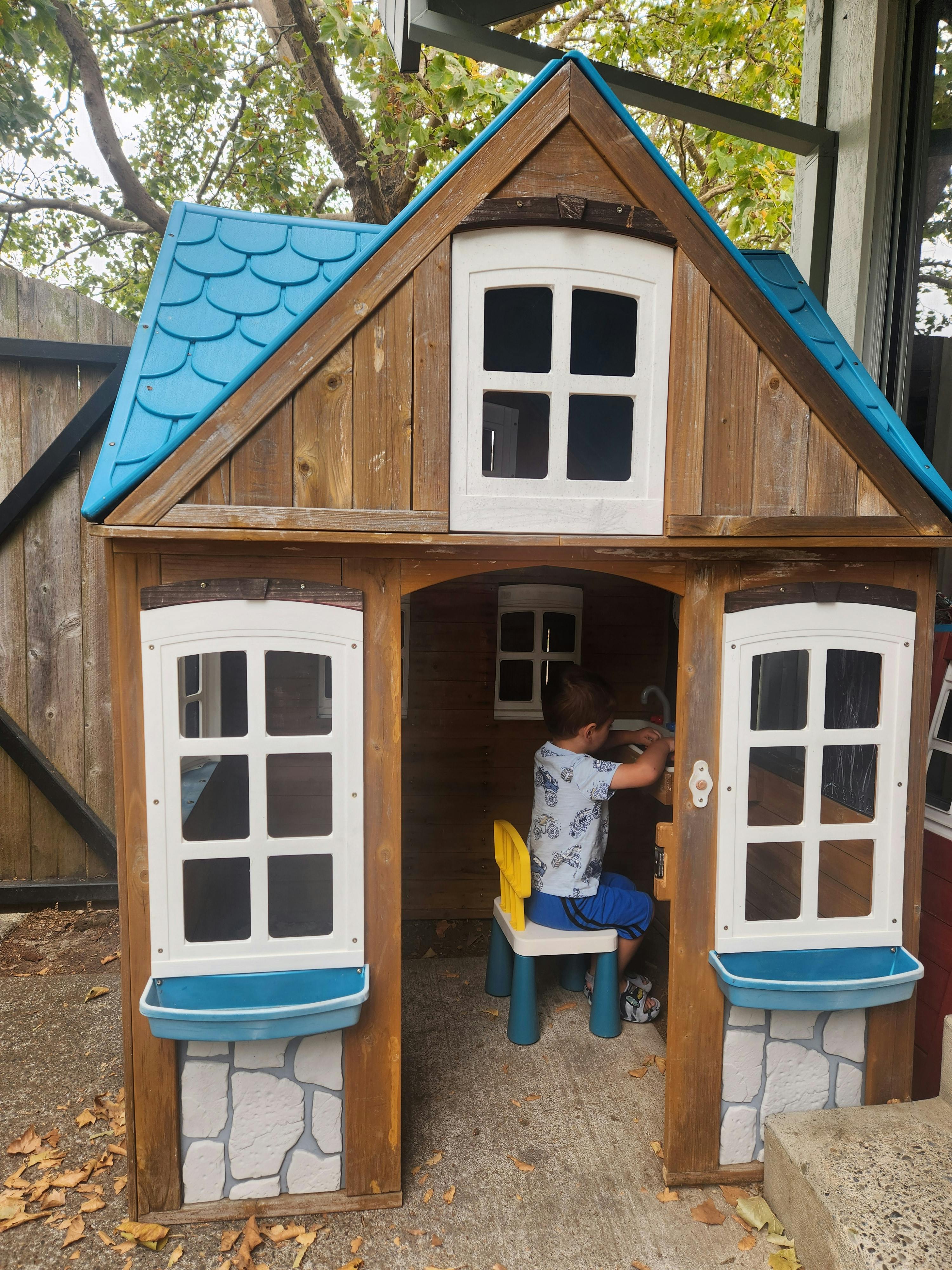 Child sitting on a chair inside a playhouse