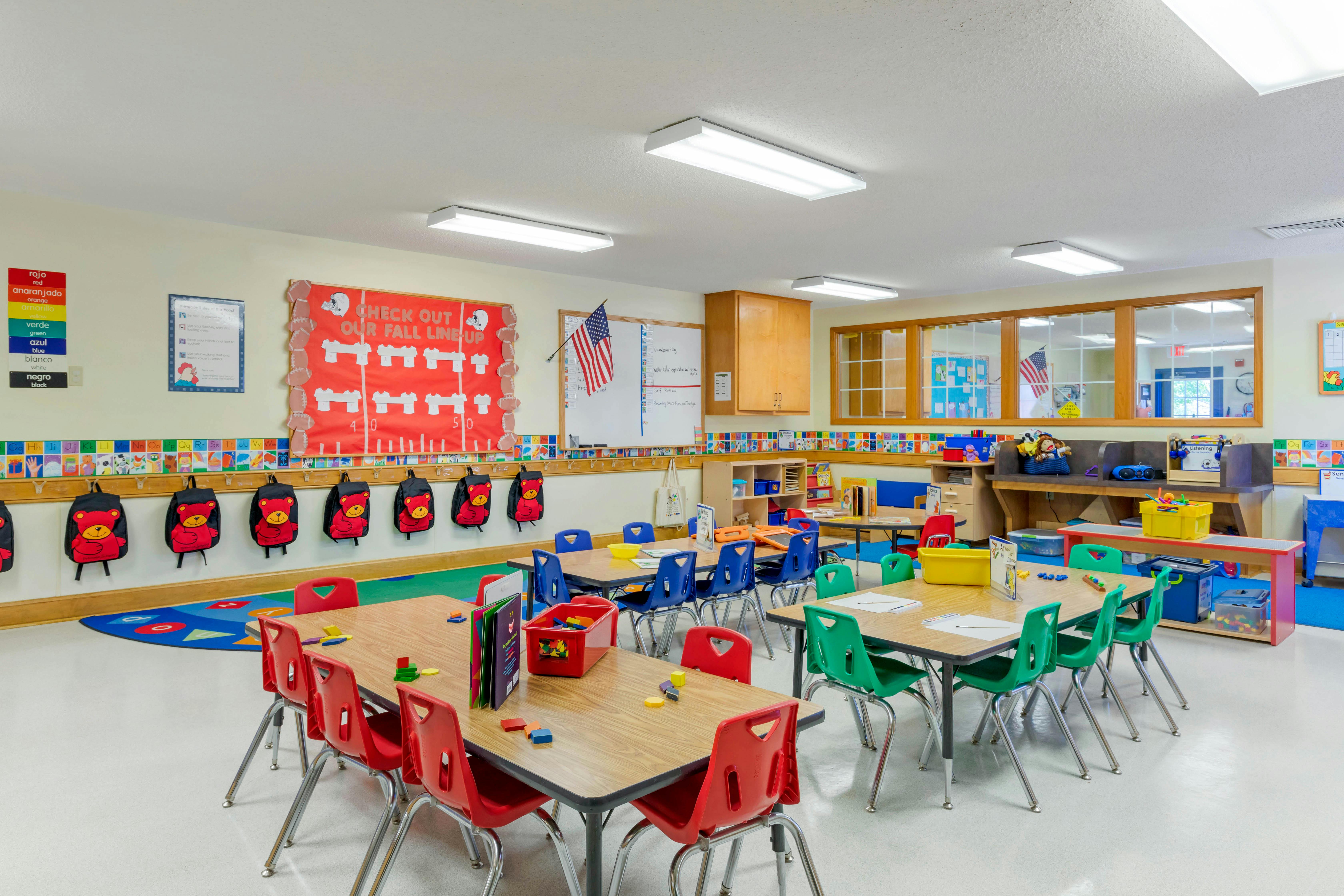 Classroom with tables, chairs, backpacks, and fall decorations