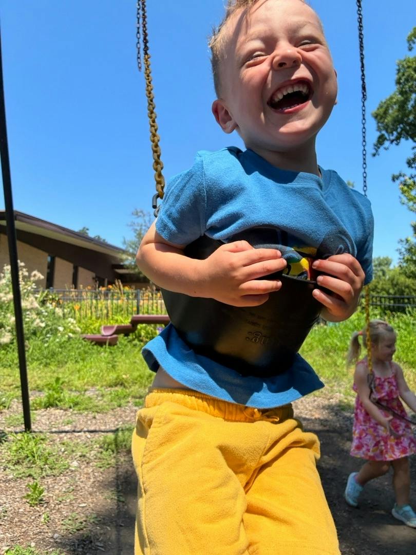 Child in a seat swing at a playground