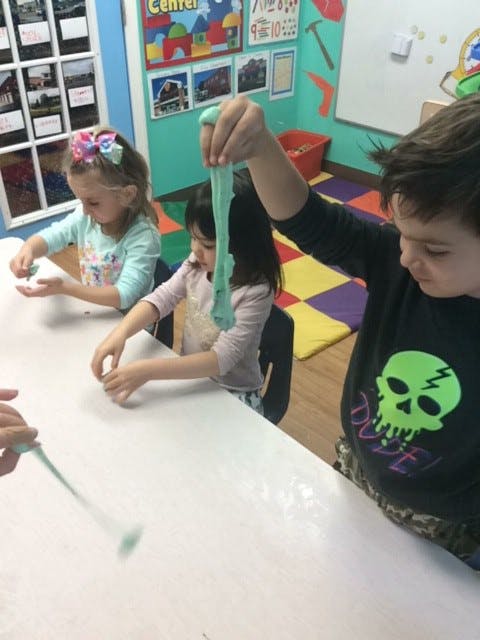 Children playing with slime at a table