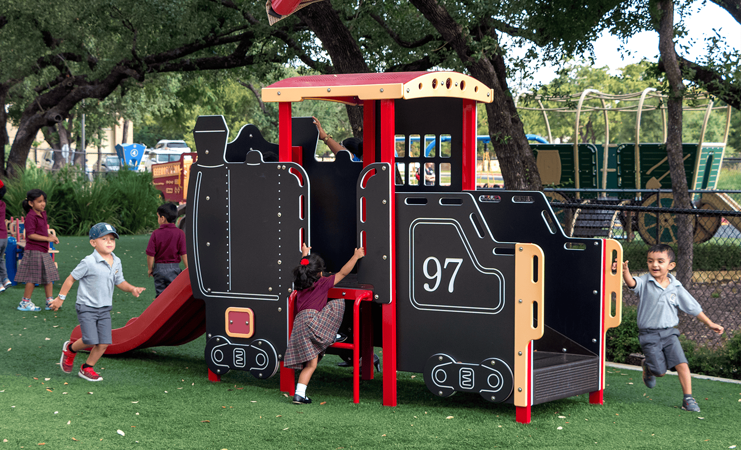 Children playing on a train-shaped playground structure