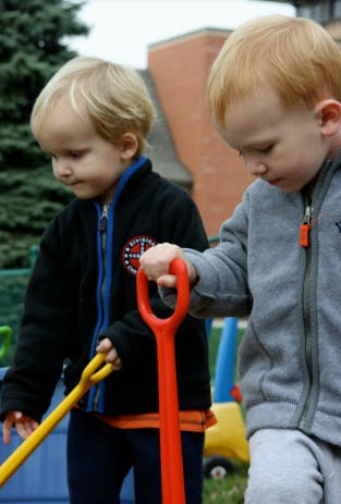Two children holding toy shovels