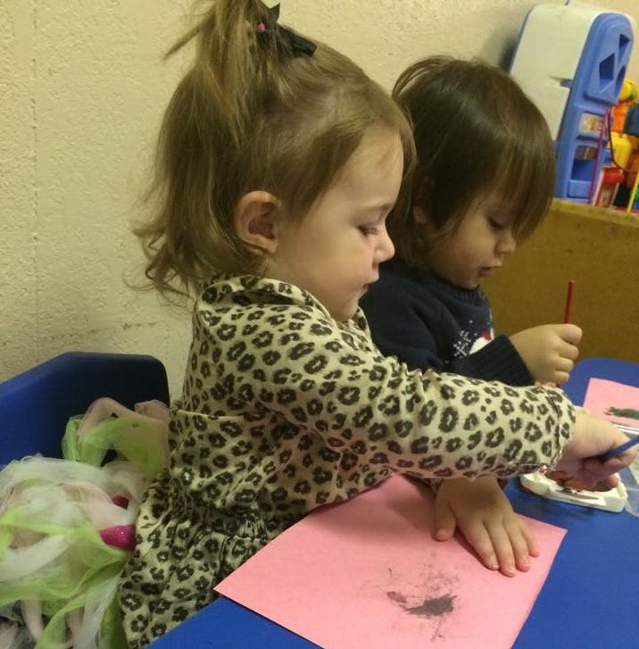 Two children painting at a table