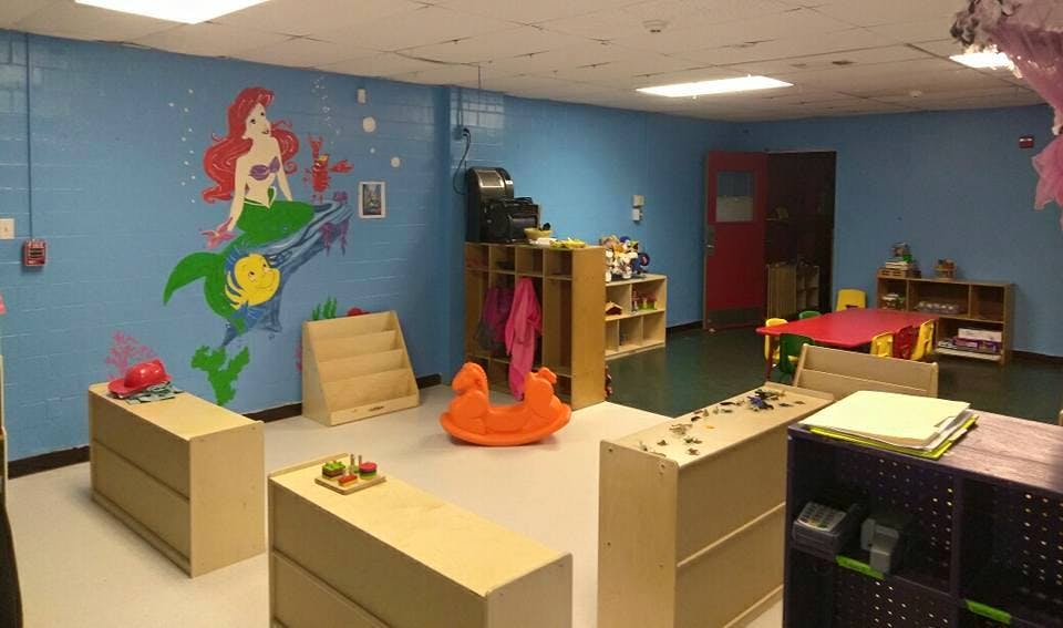 Classroom with mermaid mural, shelves, and child-sized furniture