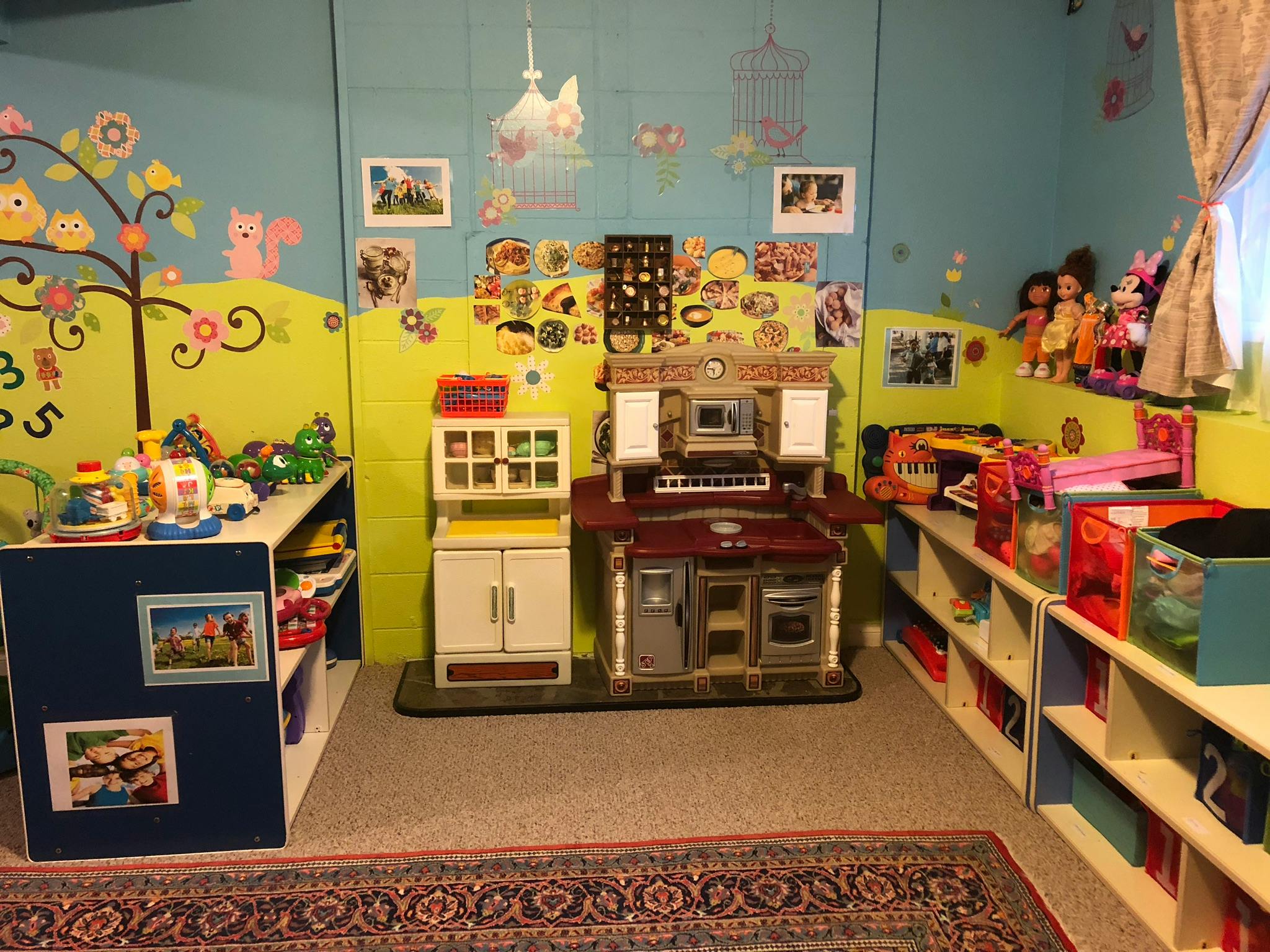 Playroom with toy kitchen, shelves, and wall decorations