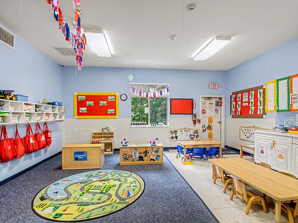 Colorful classroom with various learning stations, small tables, and storage