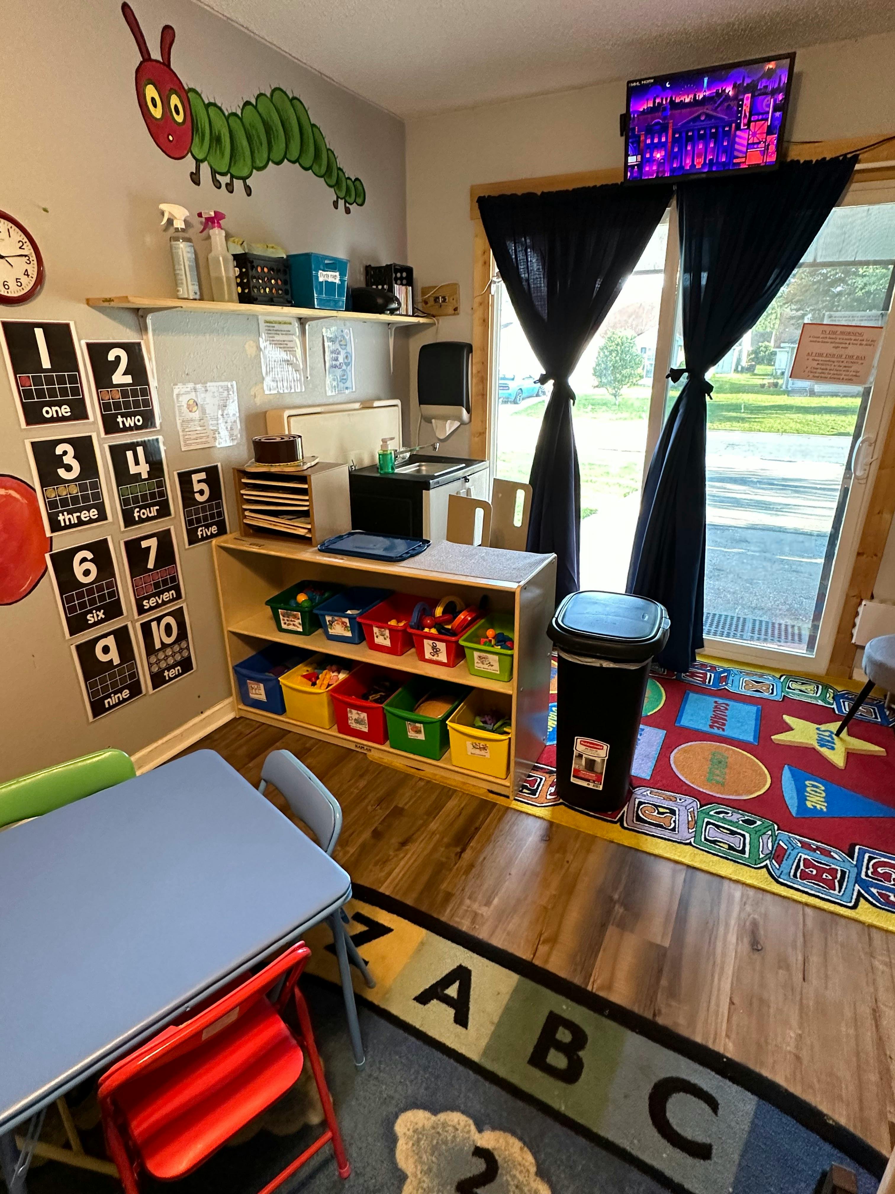 Child's play area with small table and chairs, storage, and wall decorations