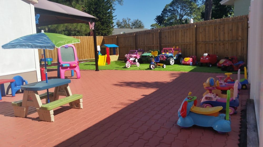 Outdoor play area with picnic table, umbrella, and various toys