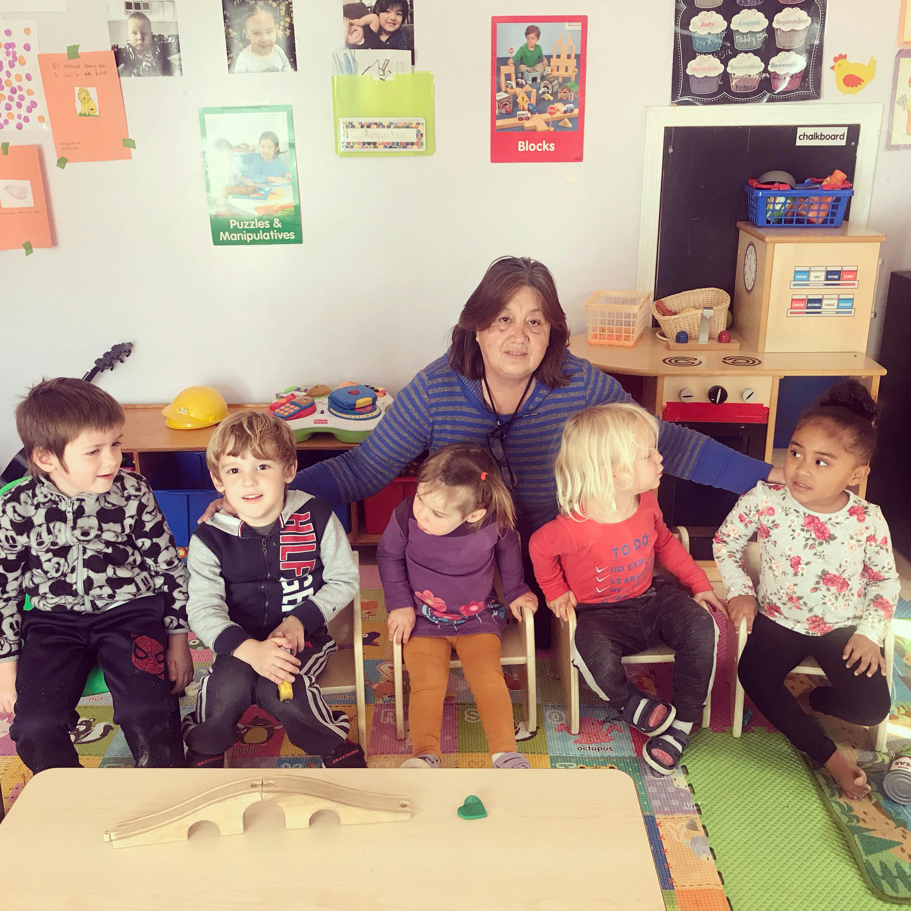 Adult with four children in a classroom