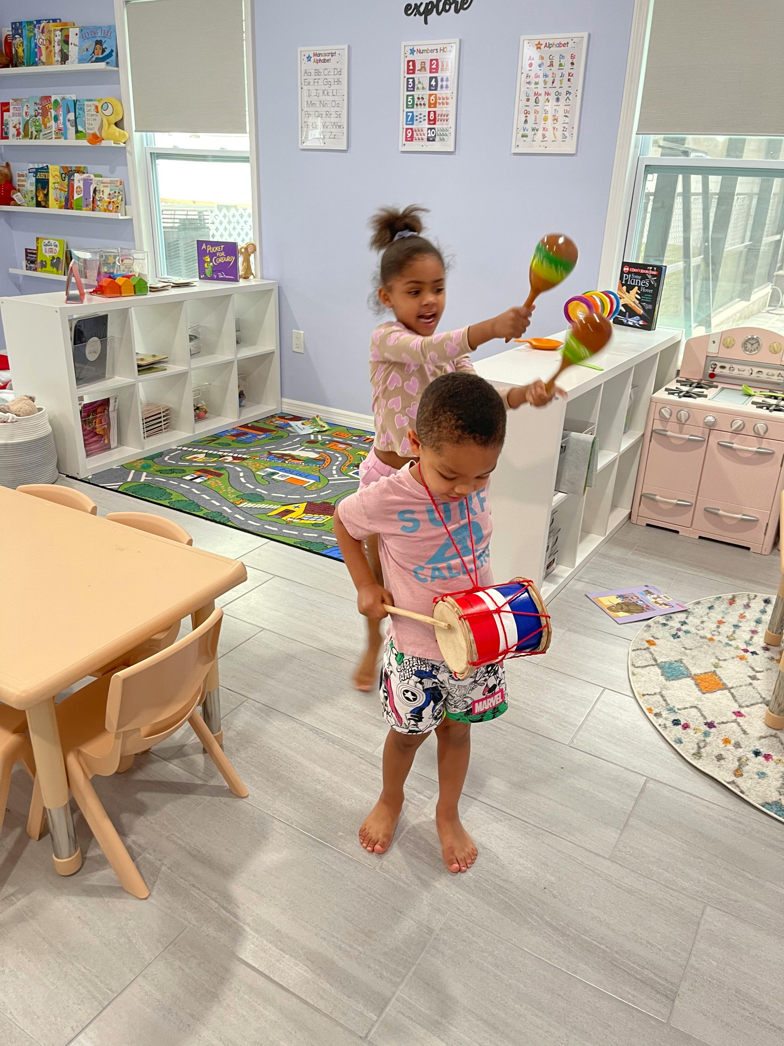 Two children playing with musical instruments in a classroom