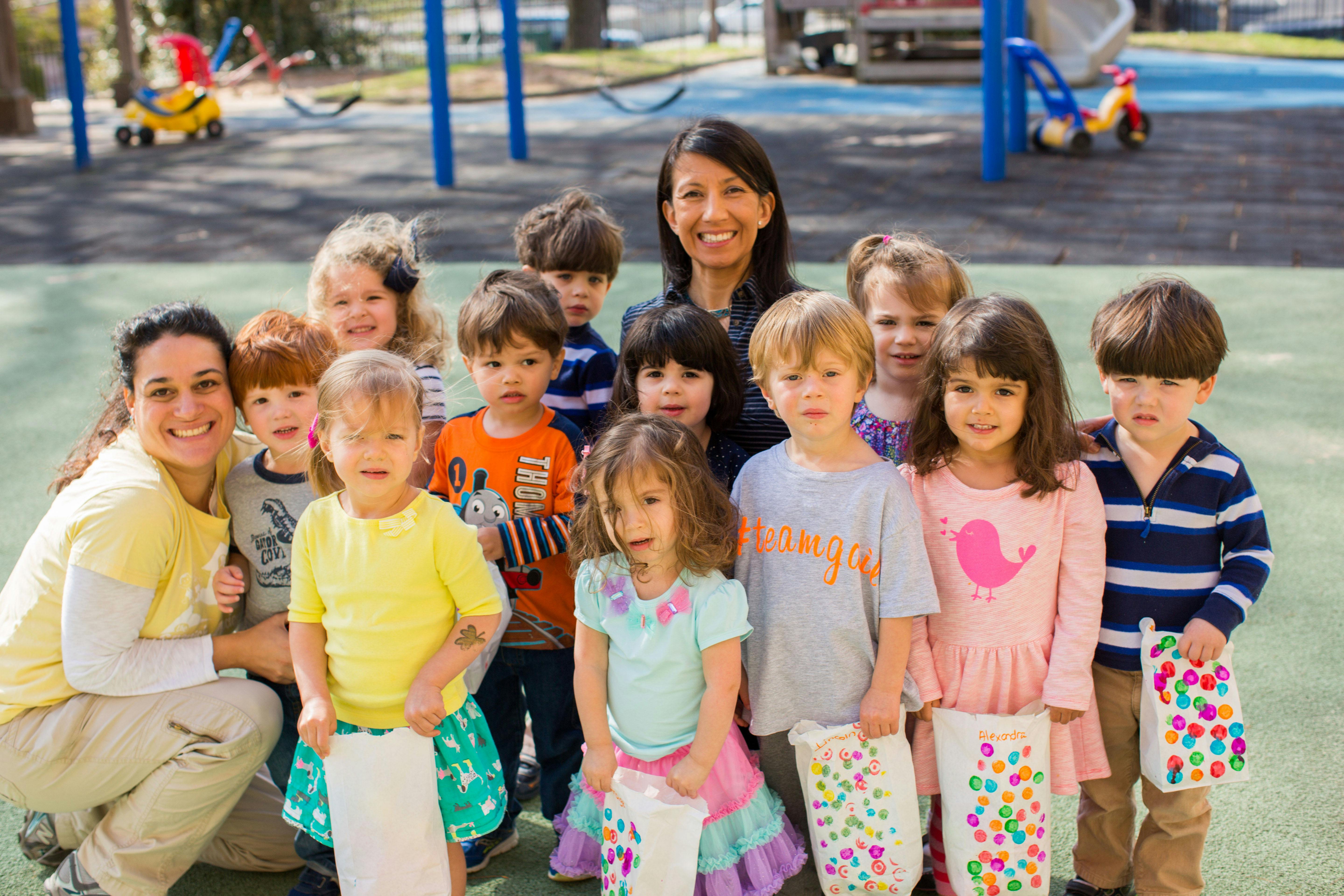 Two people with a group of children outdoors