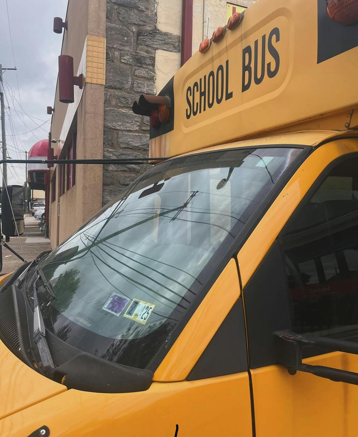 Front of a yellow school bus with "SCHOOL BUS" visible