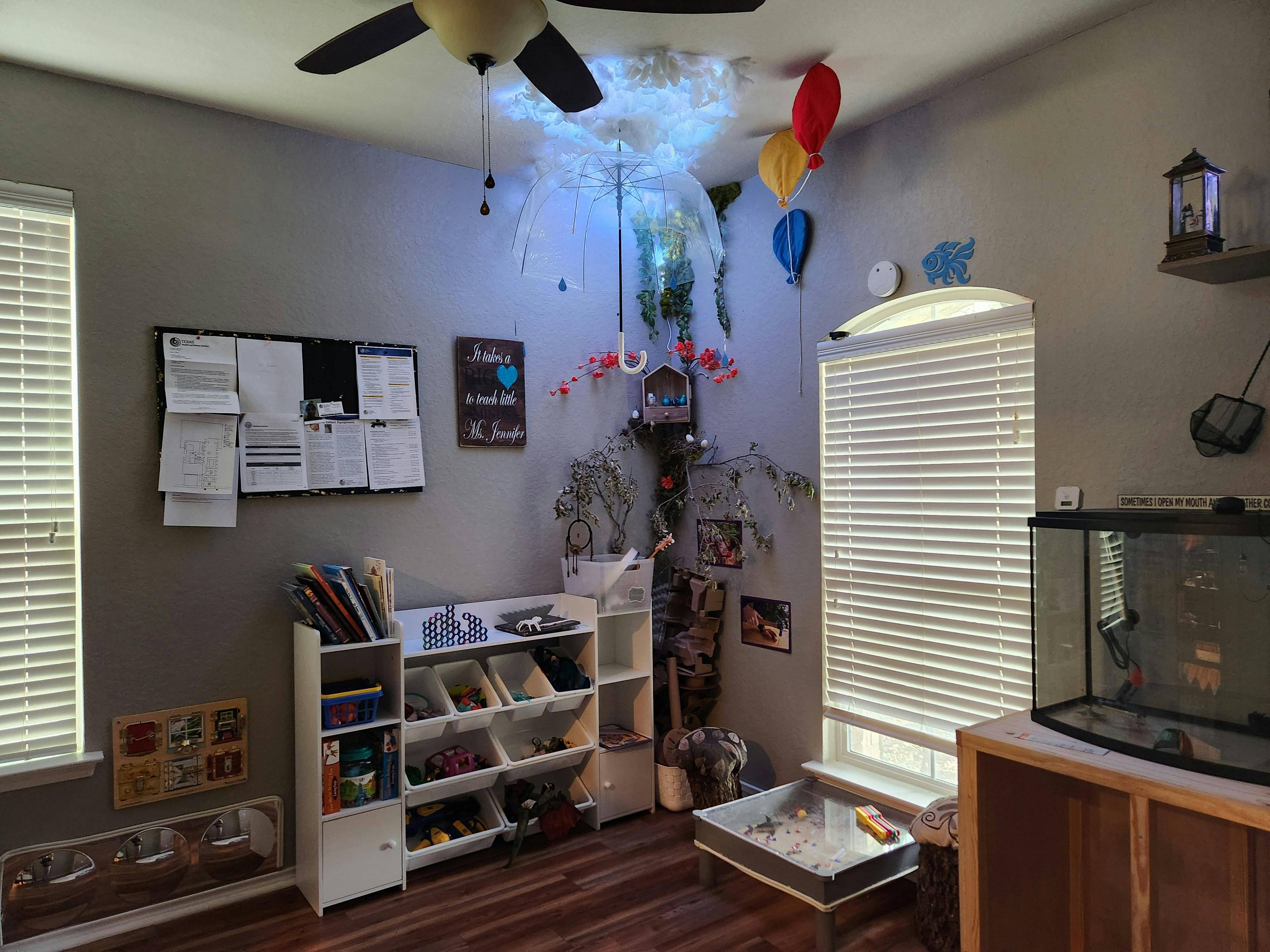 Room with a ceiling fan, bulletin board, shelves, and a fish tank