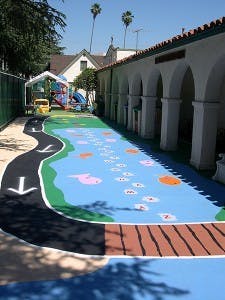 Outdoor play area with painted road and hopscotch on the ground