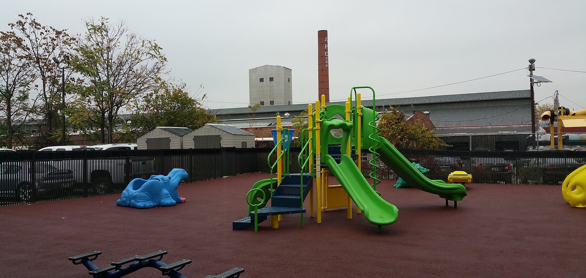 Playground with green slides and blue animal spring rider