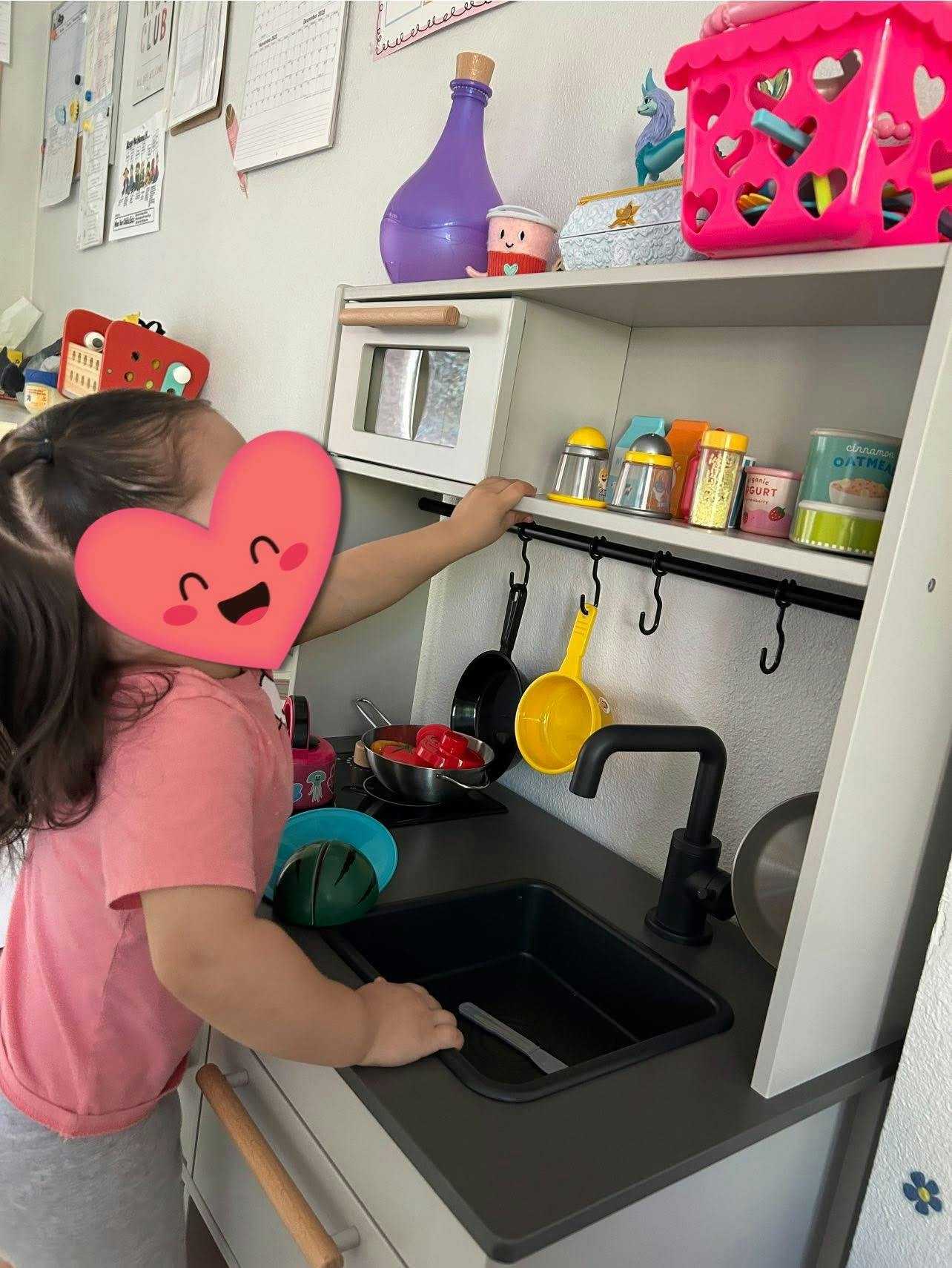 Child playing with a toy kitchen set