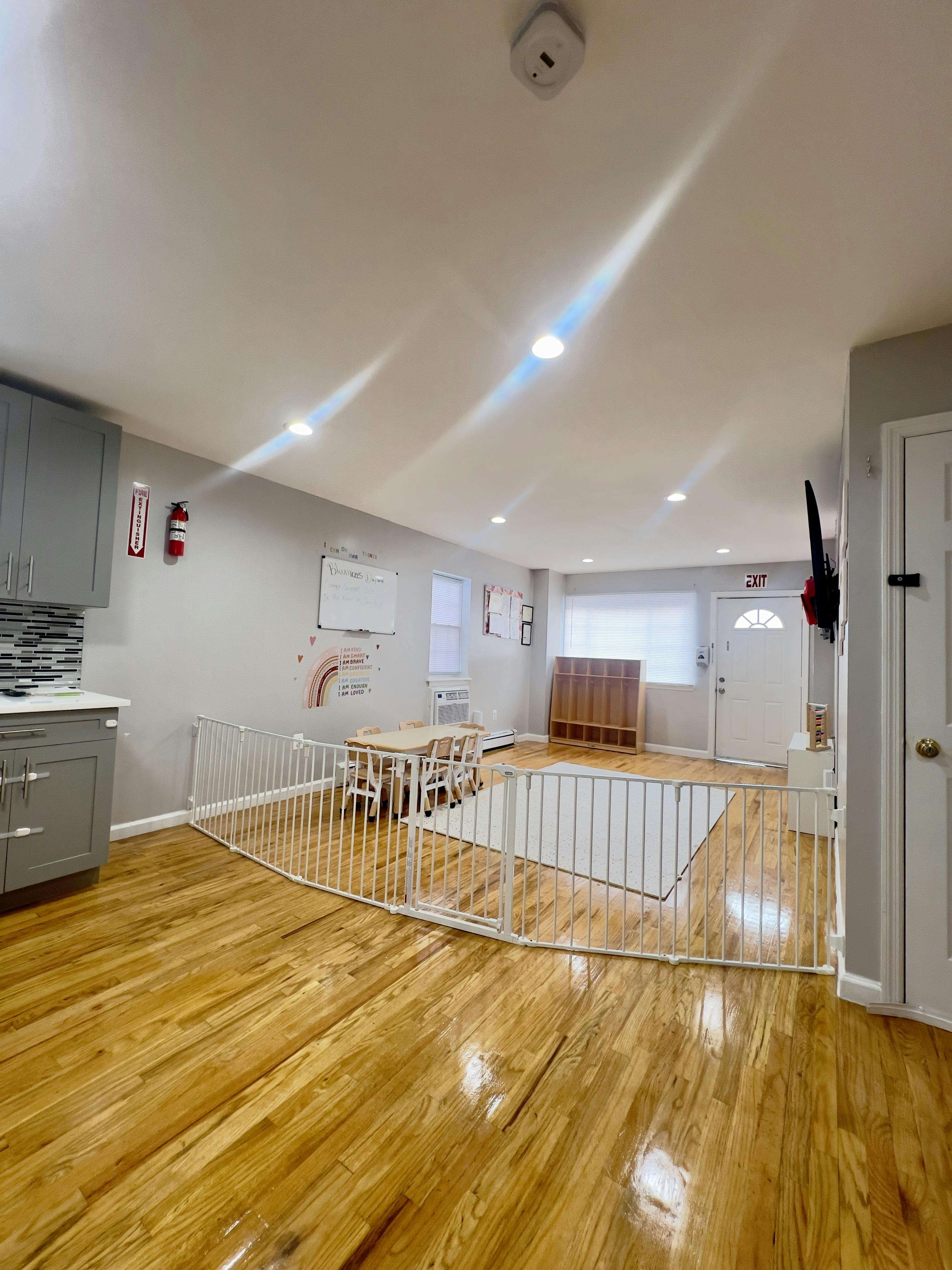 Playroom with a white safety gate enclosing a rug and small table with chairs