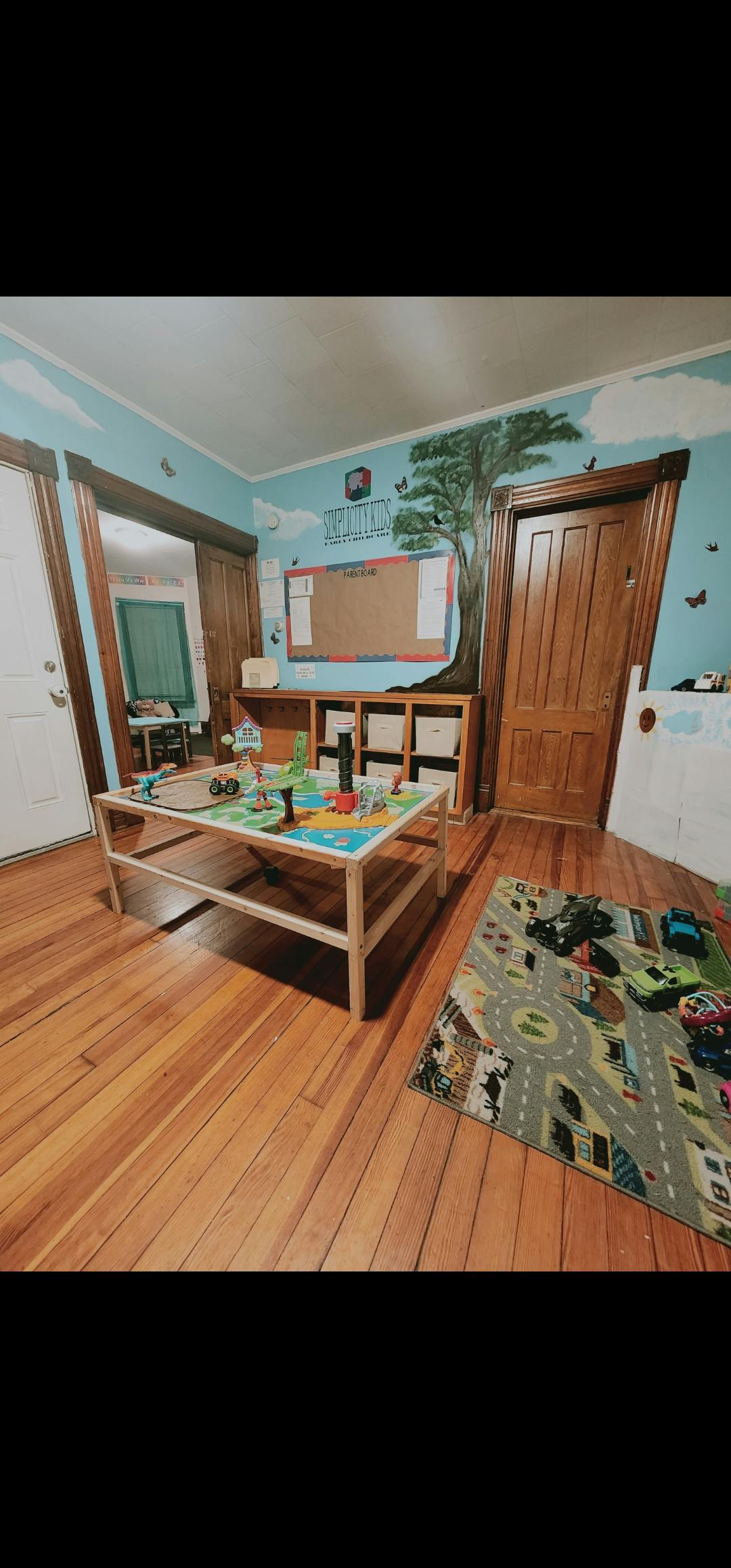 Playroom with a wooden play table and a road map rug