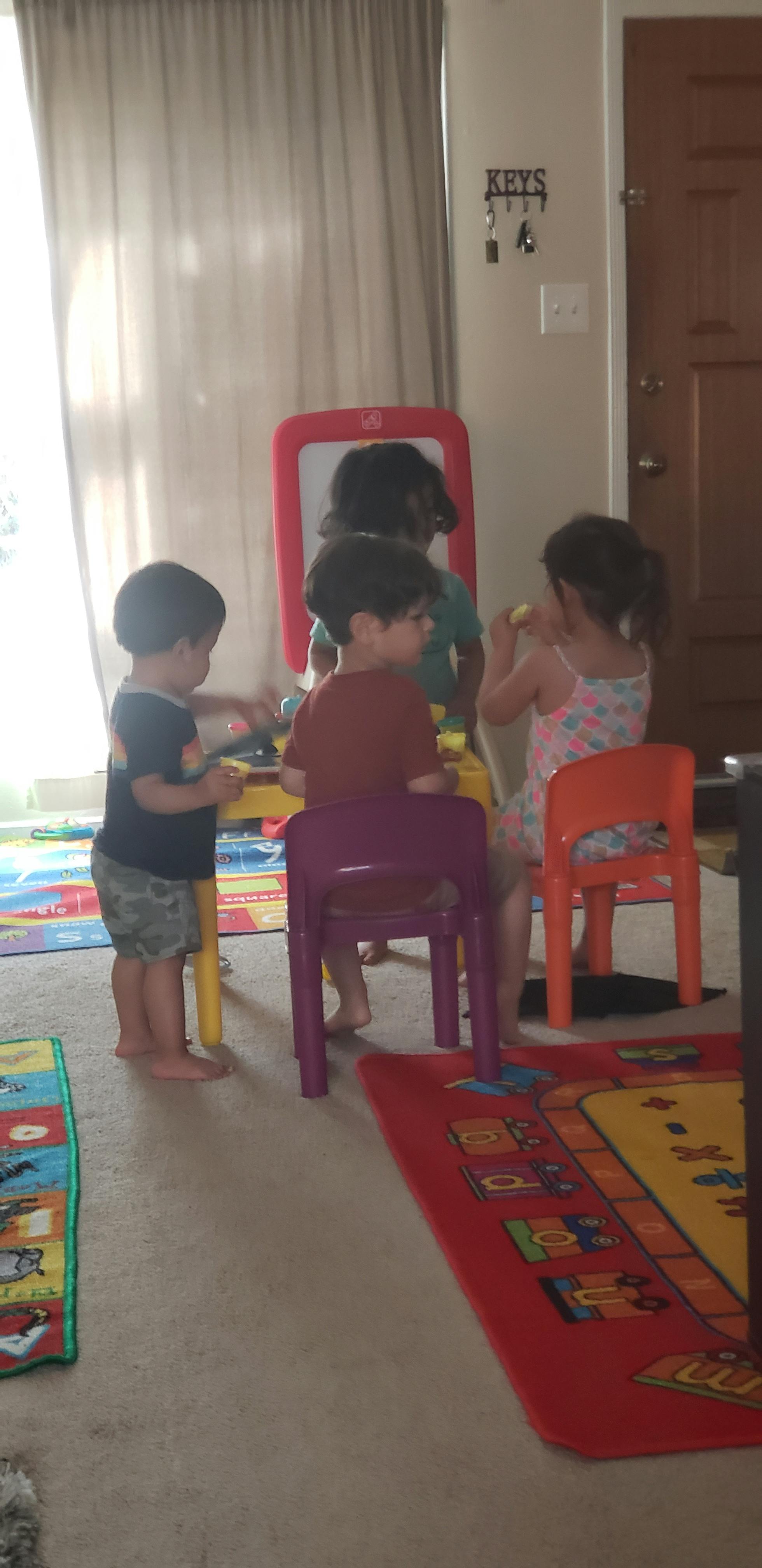 Three children playing with toys in a room