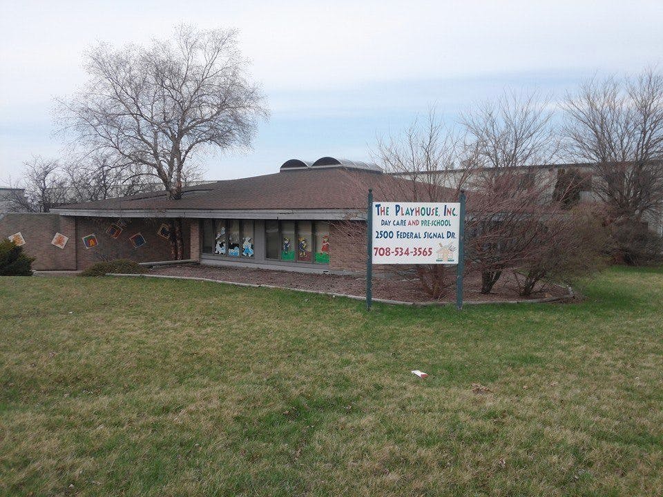 Building with a sign that reads "The Playhouse Inc"