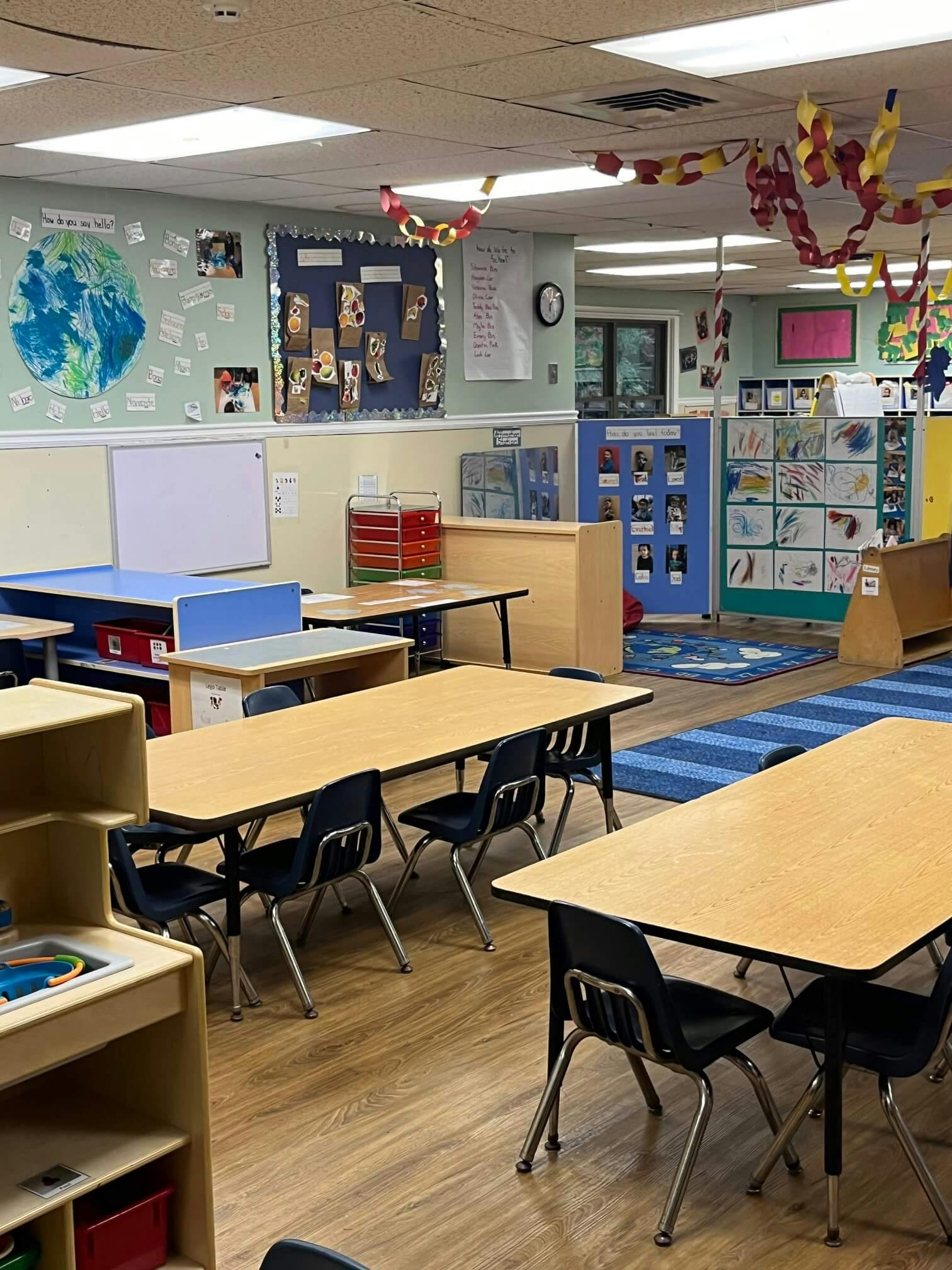 Classroom with small tables and chairs, and a whiteboard