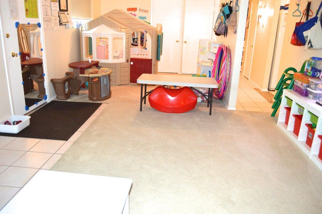 Playroom with a playhouse, small table, and red exercise ball