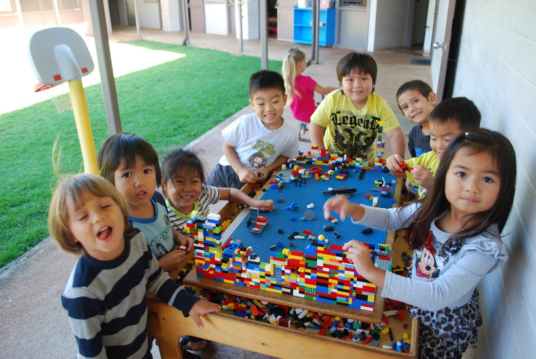 Group of children playing with building blocks at a table