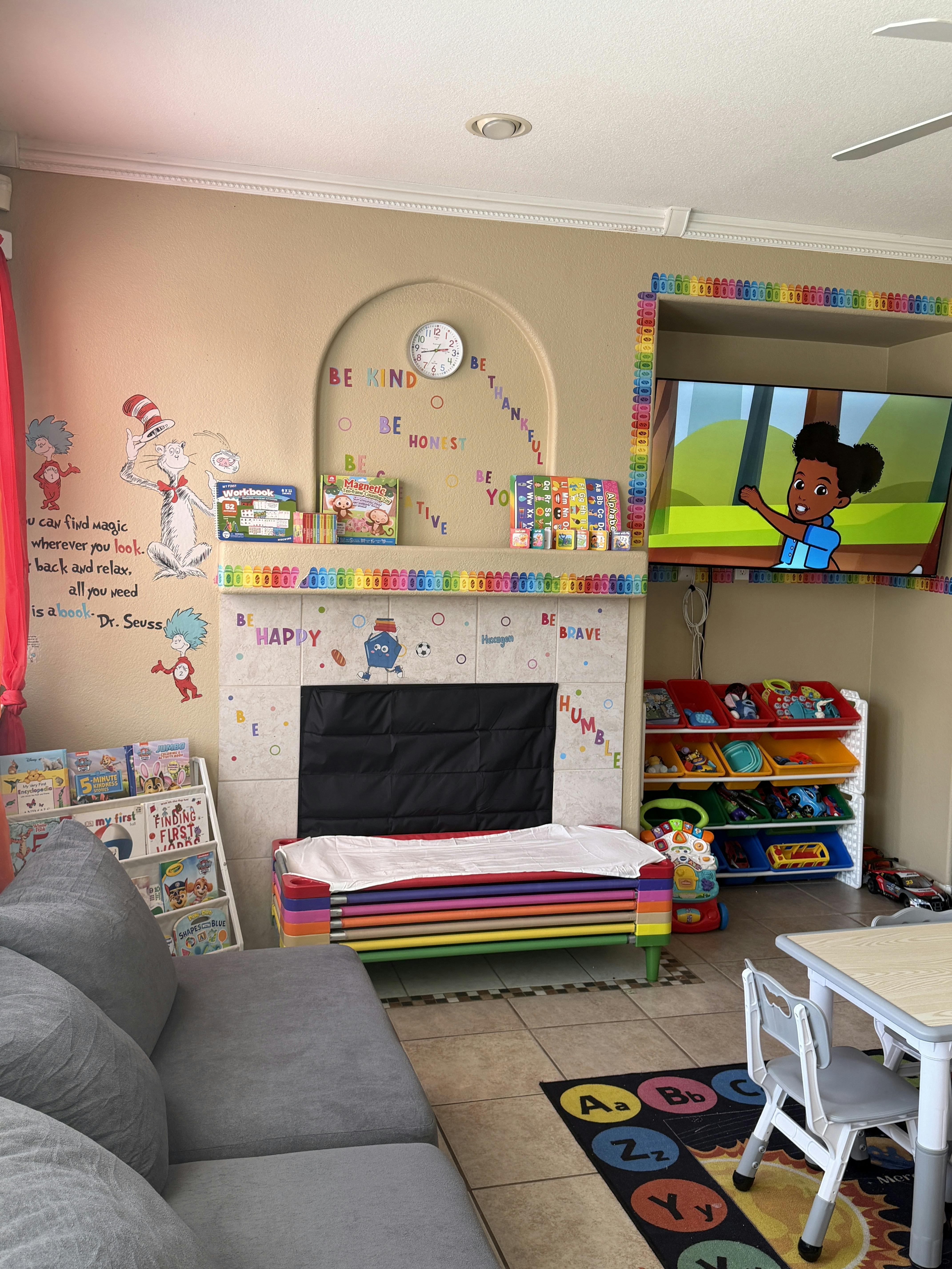 Children's playroom with cartoon wall decals, colorful furniture, and educational items
