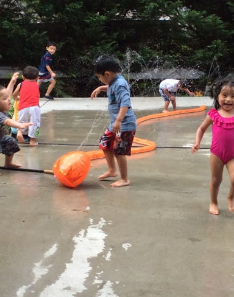 Children playing in water with an inflatable toy
